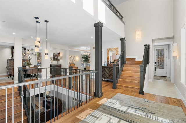 hallway featuring a towering ceiling and light hardwood / wood-style flooring