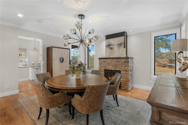 dining area featuring ornamental molding, a healthy amount of sunlight, and light hardwood / wood-style flooring