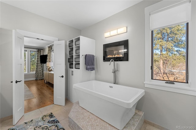 bathroom with tile patterned flooring and a tub