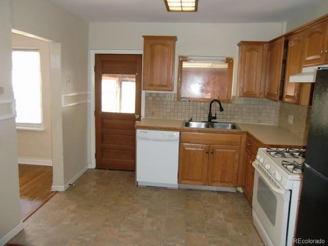 kitchen with sink, white appliances, and decorative backsplash