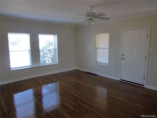 empty room with dark hardwood / wood-style floors and ceiling fan