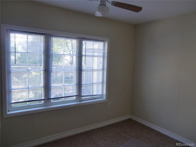 carpeted spare room featuring ceiling fan