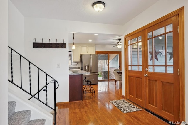 entrance foyer with ceiling fan, french doors, stairway, wood-type flooring, and recessed lighting