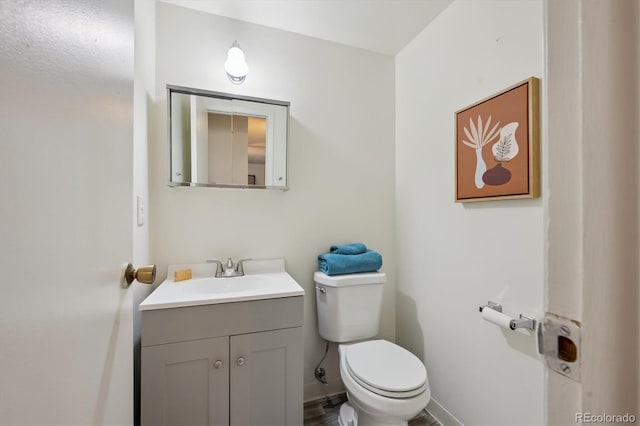 bathroom with vanity, baseboards, and toilet