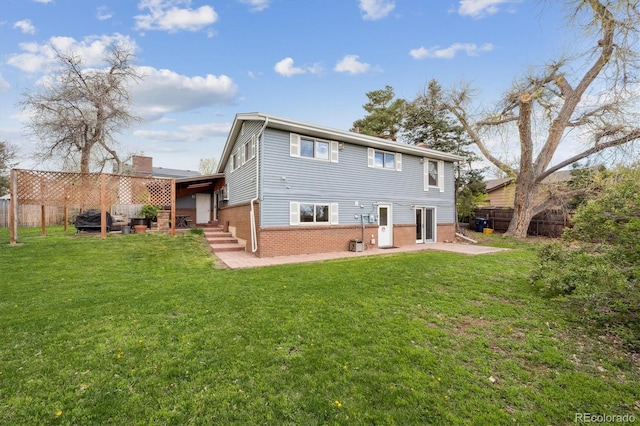rear view of property featuring fence, a patio, a yard, and brick siding