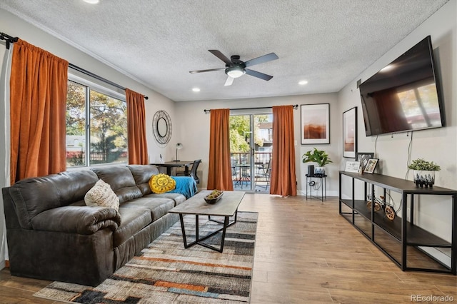 living room featuring recessed lighting, a ceiling fan, a textured ceiling, wood finished floors, and baseboards