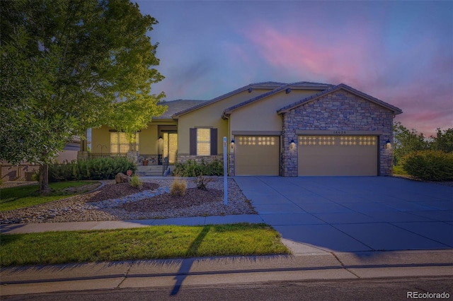 16626 Las Brisas Dr, Broomfield, CO 80023 - view of front of house featuring stone siding, a garage, driveway, and stucco siding