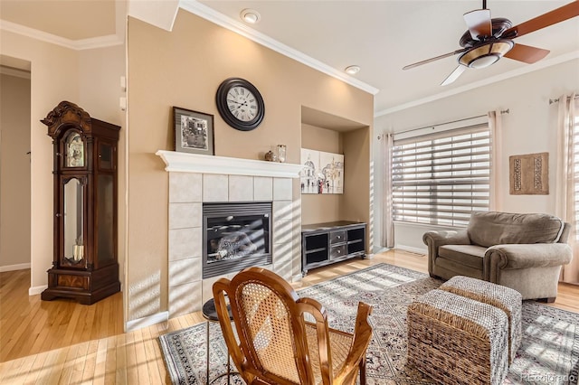 16626 Las Brisas Dr, Broomfield, CO 80023 - living room featuring light wood finished floors, crown molding, a ceiling fan, and a fireplace