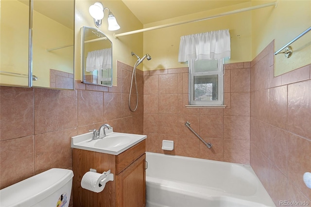 bathroom featuring washtub / shower combination, vanity, tile walls, and toilet