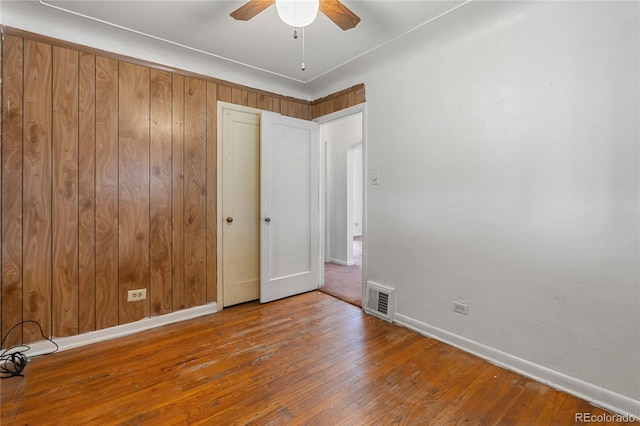 unfurnished room featuring visible vents, hardwood / wood-style flooring, baseboards, and ceiling fan