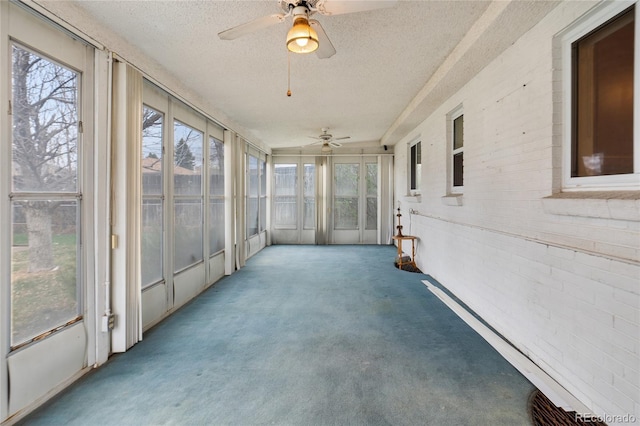 unfurnished sunroom featuring a ceiling fan