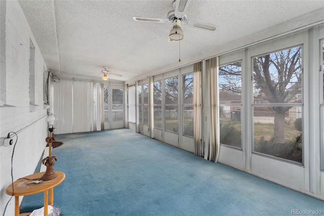 unfurnished sunroom with ceiling fan