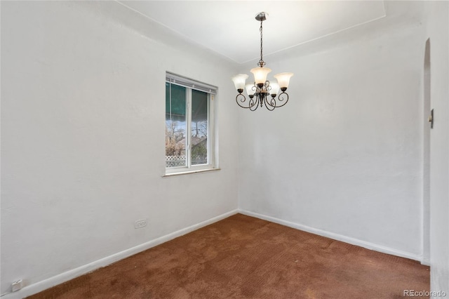 empty room with carpet floors, baseboards, and an inviting chandelier
