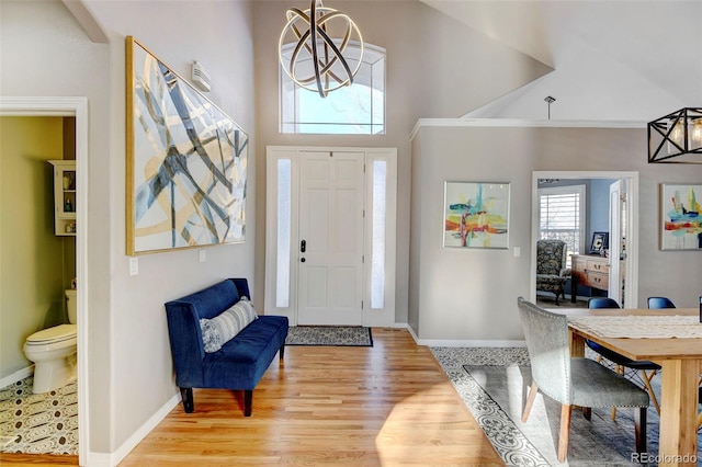 entrance foyer featuring a chandelier, a high ceiling, and light wood-type flooring