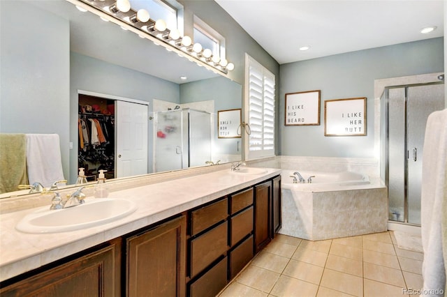 bathroom with tile patterned floors, vanity, and shower with separate bathtub