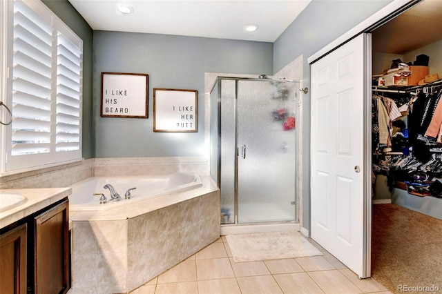 bathroom featuring tile patterned flooring, vanity, and shower with separate bathtub