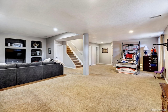 interior space featuring built in shelves, light colored carpet, and a textured ceiling