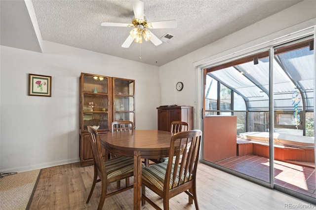 dining space featuring ceiling fan, a textured ceiling, and light hardwood / wood-style floors