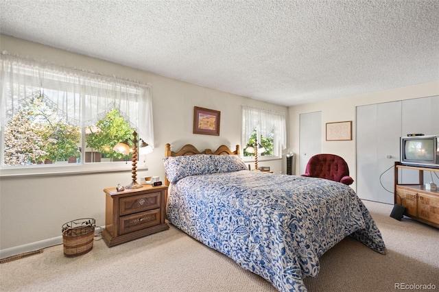 carpeted bedroom featuring a textured ceiling