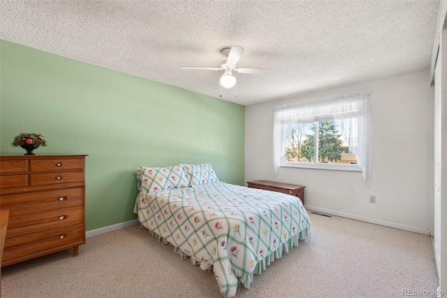 carpeted bedroom with a textured ceiling and ceiling fan