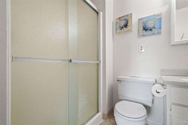 bathroom featuring vanity, a shower with shower door, and toilet