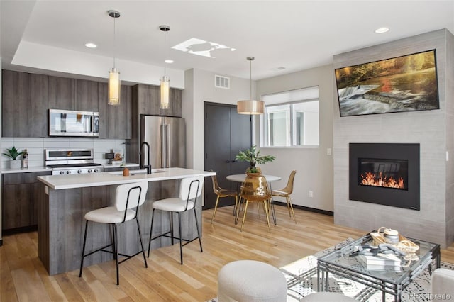 kitchen featuring stainless steel appliances, light countertops, visible vents, and modern cabinets