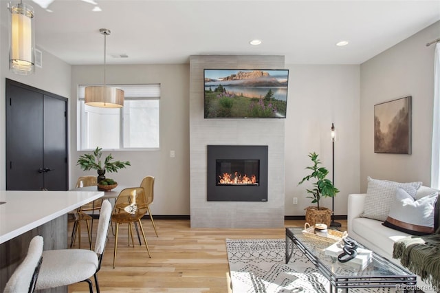 living room with light wood finished floors, a fireplace, visible vents, and recessed lighting