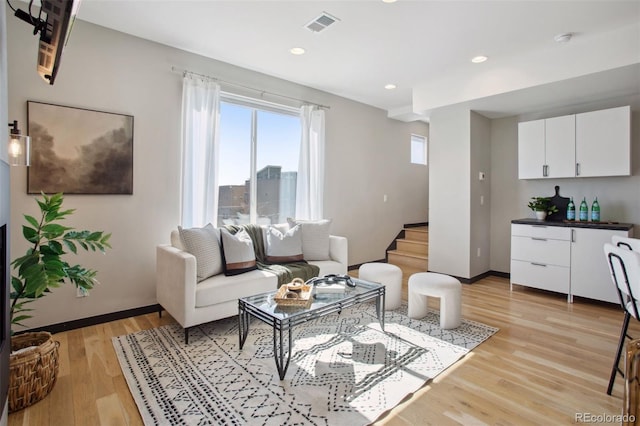 living room with light wood finished floors, recessed lighting, visible vents, stairway, and baseboards