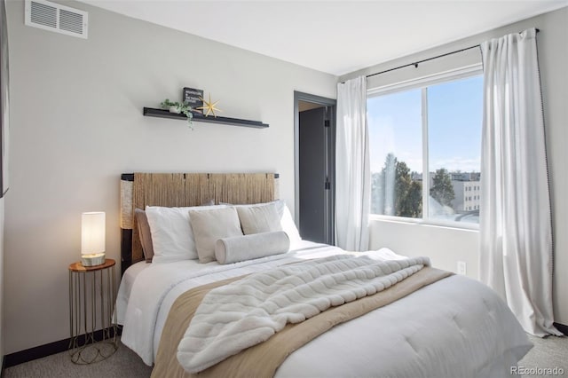 carpeted bedroom featuring baseboards and visible vents