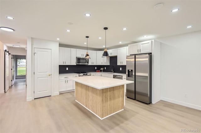 10295 E Evans Ave Unit 114, Aurora, CO 80247 - kitchen featuring stainless steel appliances, light wood-style floors, a kitchen island, tasteful backsplash, and recessed lighting