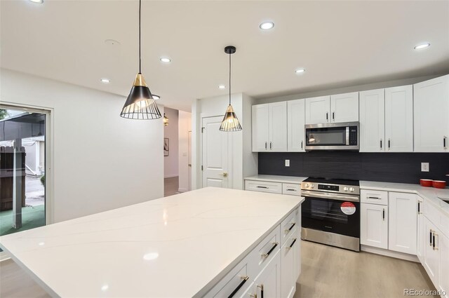 10295 E Evans Ave Unit 114, Aurora, CO 80247 - kitchen with stainless steel microwave, wall oven, light wood-type flooring, white cabinetry, and backsplash