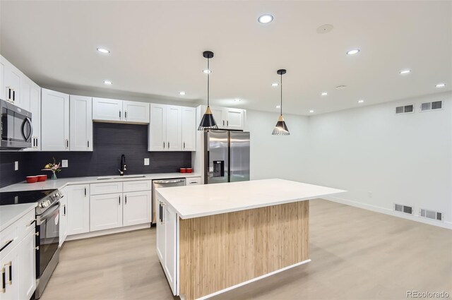 10295 E Evans Ave Unit 114, Aurora, CO 80247 - kitchen with stainless steel appliances, decorative backsplash, a center island, recessed lighting, and light wood-style floors