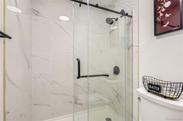 10295 E Evans Ave Unit 114, Aurora, CO 80247 - bathroom featuring toilet and a marble finish shower
