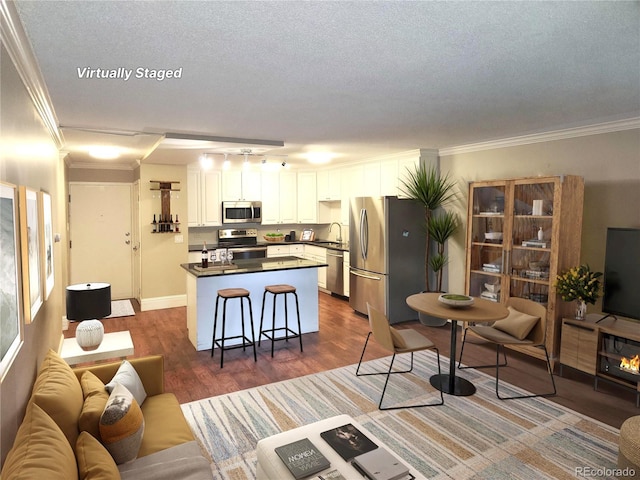 9300 E Center Ave Unit 6A, Denver, CO 80247 - living area with crown molding, dark wood finished floors, and a textured ceiling