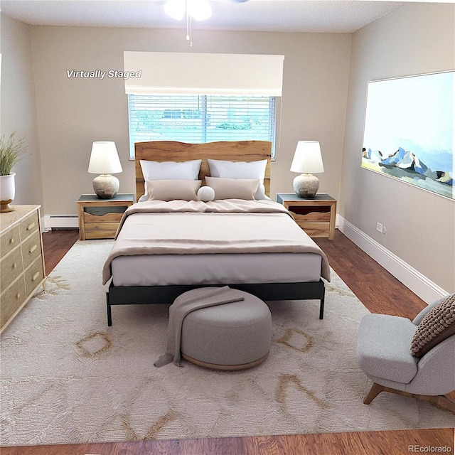 9300 E Center Ave Unit 6A, Denver, CO 80247 - bedroom featuring a baseboard heating unit and wood finished floors