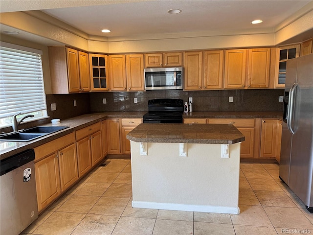 20304 E 47th Pl, Denver, CO 80249 - kitchen featuring appliances with stainless steel finishes, a sink, tile counters, a center island, and a breakfast bar area