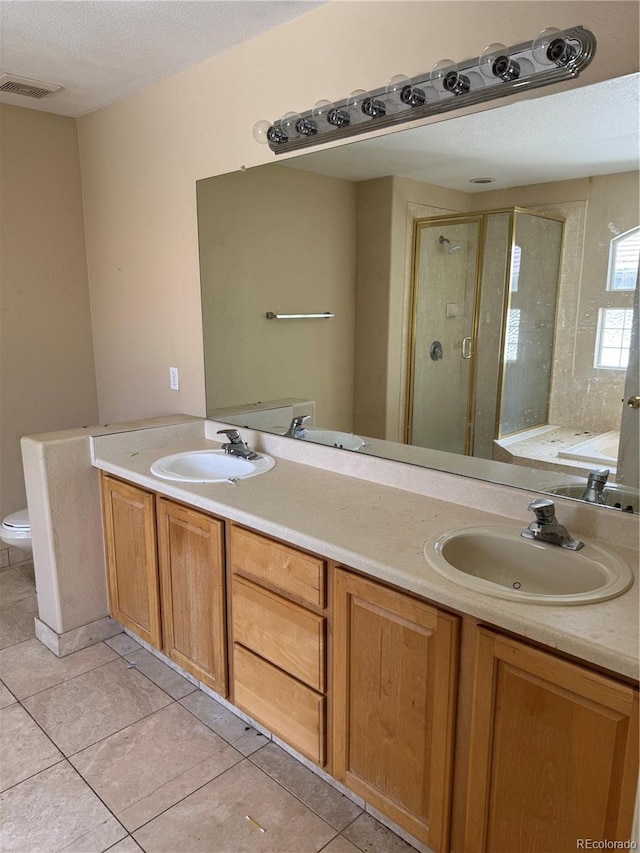 20304 E 47th Pl, Denver, CO 80249 - bathroom featuring a shower stall, double vanity, toilet, tile patterned floors, and a textured ceiling