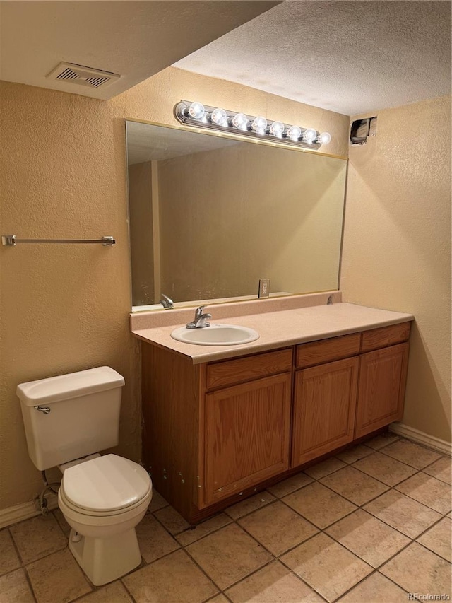 20304 E 47th Pl, Denver, CO 80249 - bathroom with tile patterned floors, toilet, vanity, baseboards, and a textured wall
