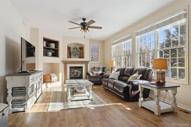 living room featuring light hardwood / wood-style floors and ceiling fan