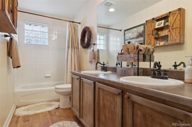 full bathroom featuring hardwood / wood-style flooring, toilet, vanity, and shower / bathtub combination with curtain