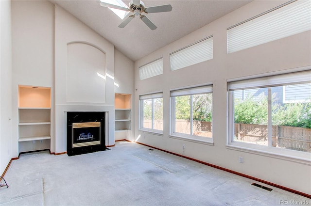 unfurnished living room featuring high vaulted ceiling, carpet flooring, plenty of natural light, and baseboards