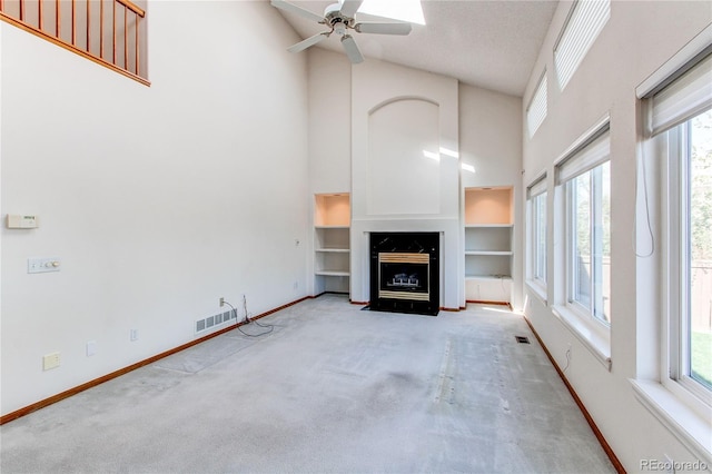 unfurnished living room with high vaulted ceiling, baseboards, carpet, healthy amount of natural light, and ceiling fan