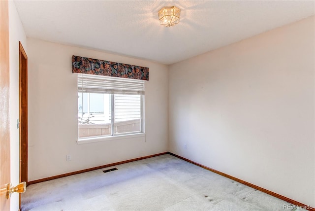 carpeted spare room featuring baseboards