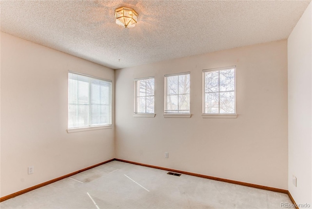 carpeted empty room featuring baseboards and a textured ceiling