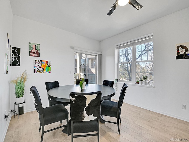 dining room featuring a ceiling fan, light wood-style flooring, and baseboards