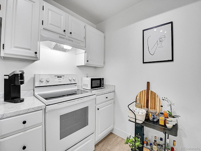 kitchen with white appliances, white cabinets, under cabinet range hood, and light wood finished floors