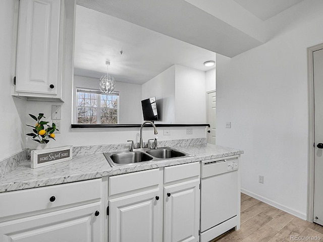 kitchen with light countertops, light wood-style flooring, white cabinetry, a sink, and dishwasher