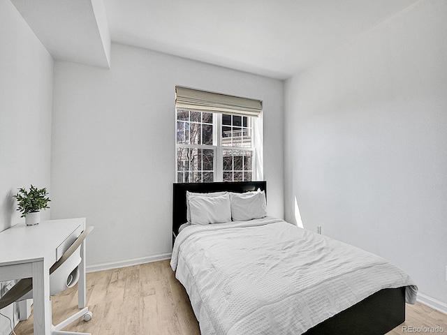 bedroom featuring light wood-style flooring and baseboards