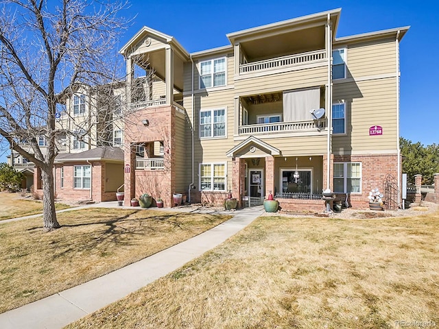 townhome / multi-family property featuring brick siding and a front lawn