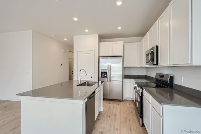 kitchen featuring sink, light hardwood / wood-style flooring, stainless steel appliances, a kitchen island with sink, and white cabinets